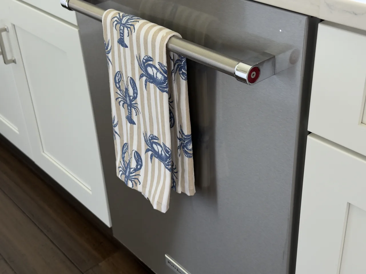 A crab-print towel hung neatly after a kitchen clean